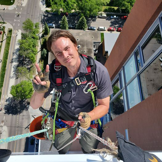 Heights Residential crew member washing windows on bosuns chair